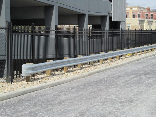 fencing and guard rail separating parking garage and parking lot